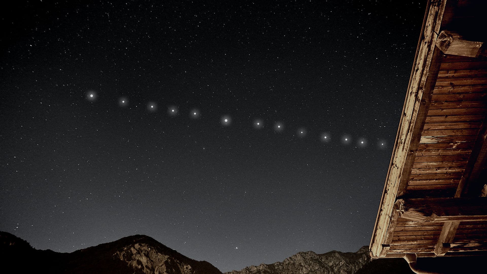 Satélites Starlink cruzando o céu noturno sobre montanhas